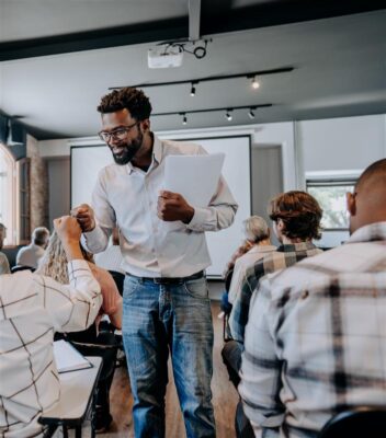 Photo of facilitator handing out documents in a classroom
